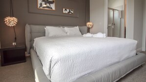 A modern bedroom with a large bed, two wall-mounted lamps, and artwork above the bed. - Encore Resort at Reunion 480 1825.8 (Kissimmee)