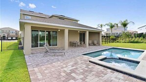 A modern house with a swimming pool, patio furniture, and a well-maintained lawn. - Encore Resort at Reunion 380 (Kissimmee)