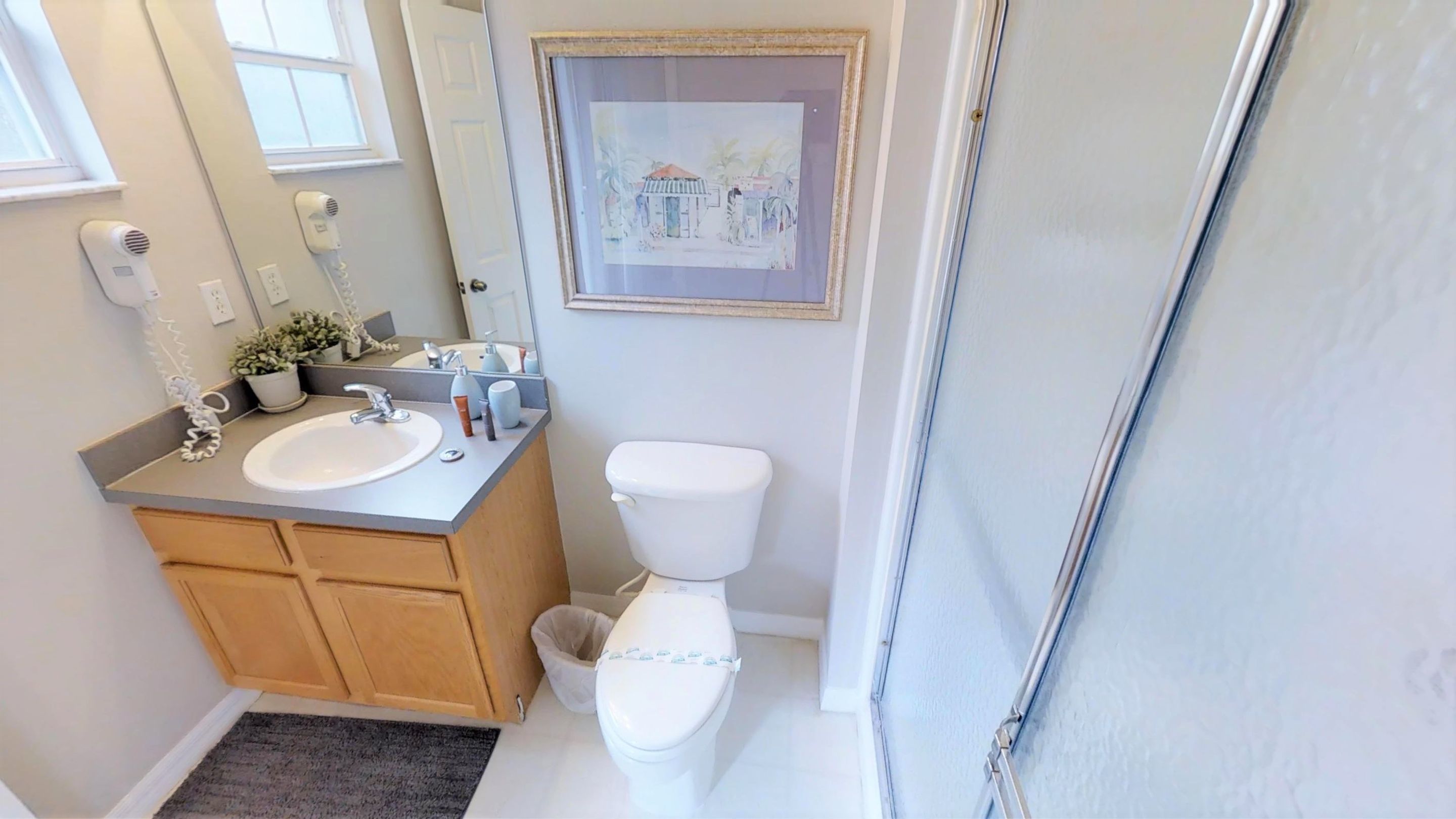 Ein Badezimmer mit einem Doppelwaschbecken, Toilette und Duschbereich.