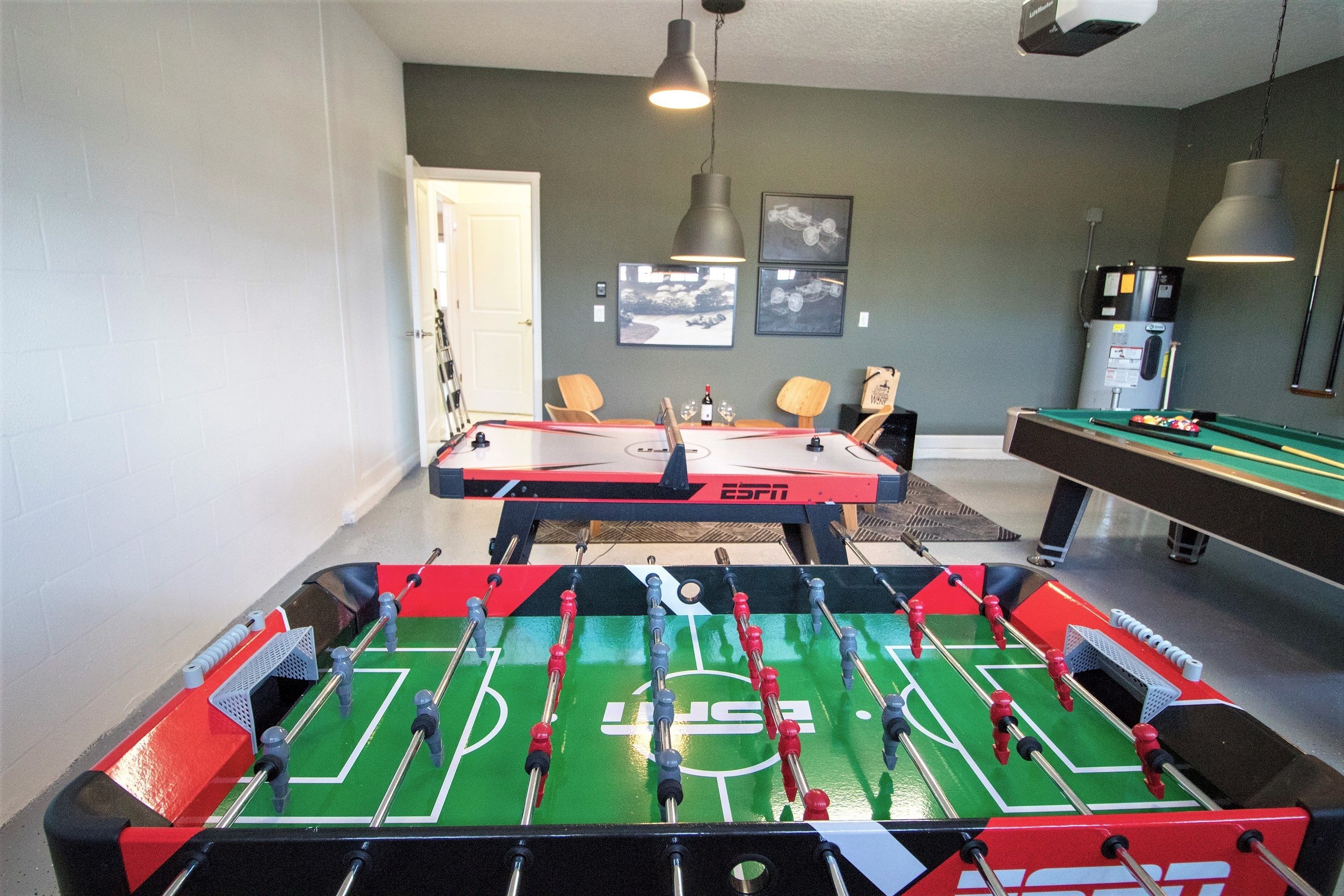 Une pièce équipée d’un baby-foot, d’une table de billard et d’un espace détente avec des fauteuils.