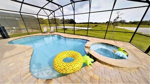 An indoor swimming pool with two hot tubs, surrounded by a glass enclosure.
