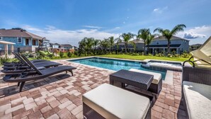 A swimming pool area with lounge chairs and a hot tub. - Encore Resort at Reunion 7717 (Kissimmee)