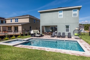 A residential property with a swimming pool, outdoor seating, and a covered patio area. - Encore Resort at Reunion 7717 (Kissimmee)