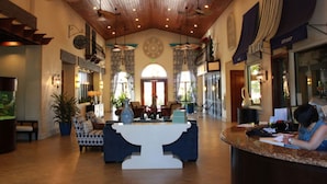 A spacious lobby with a high ceiling, wooden beams, and a reception desk. - Paradise Palms 2959 (Kissimmee)