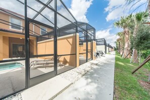 Ein modernes Gebäude mit großen Glasfenstern, einem Pool und einem Palmengarten-Weg.