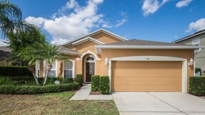 A residential house with a garage, a well-maintained lawn, and a palm tree. - The Shire at West Haven 108 (Davenport)
