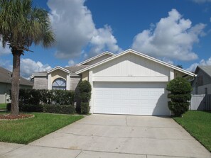 A residential house with a garage, a driveway, and a well-maintained lawn.