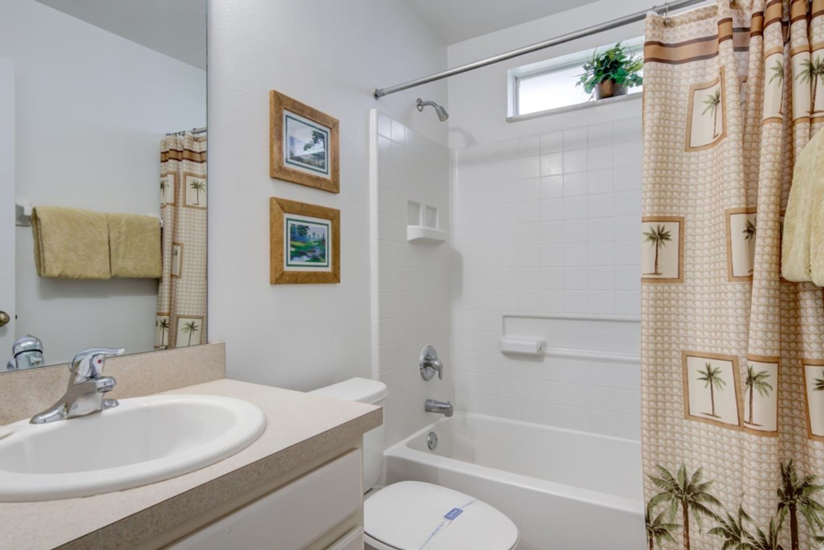 A bathroom with a sink, toilet, shower, and a towel rack.