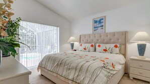 Un dormitorio con una cama grande, dos mesitas de noche, una ventana con persianas y una planta en maceta.