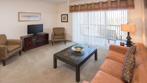 A living room with a sofa, armchair, and a coffee table. - Palisades Resort 14200 - 409 (Winter Garden)