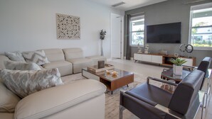 Ein modernes Wohnzimmer mit einer Couch, einem Couchtisch und einem Fernseher.
