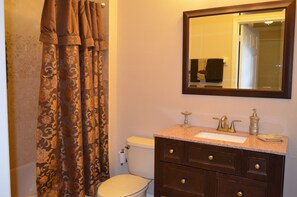 A bathroom with a toilet, sink, and mirror. - Windsor Palms 2303 - 203 (Kissimmee)