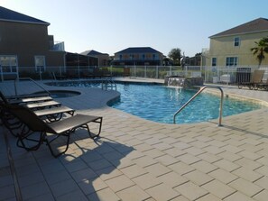 A swimming pool with lounge chairs and a small waterfall feature. - Serenity 1539 (Clermont)
