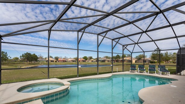 Una piscina coperta con idromassaggio, lettini e vista sulle case sullo sfondo.