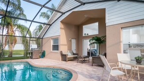 An indoor swimming pool with a patio area, including seating and a table. - Indian Creek 8115 (Kissimmee)