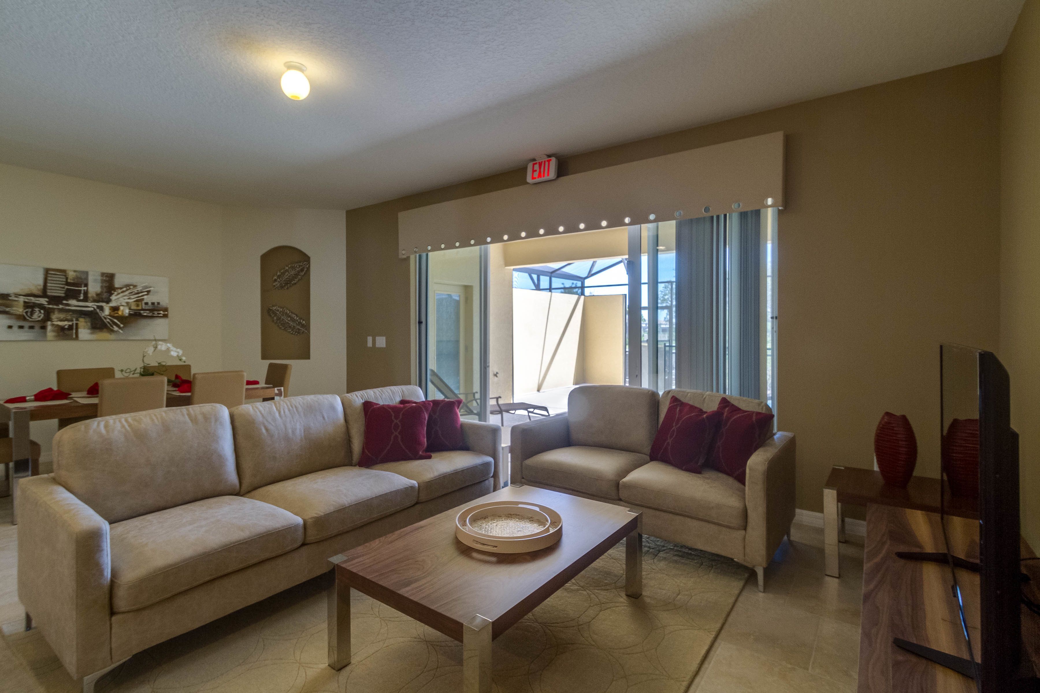 A modern living room with two sofas, a coffee table, and a large mirror with lights.