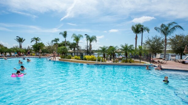 A large outdoor swimming pool surrounded by palm trees and lounge chairs. - Vista Cay 4804 B12.403 (Orlando)
