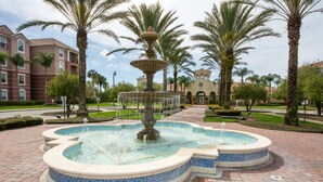 A fountain with a tiered design surrounded by palm trees and a brick pathway. - Vista Cay 4804 B12.403 (Orlando)