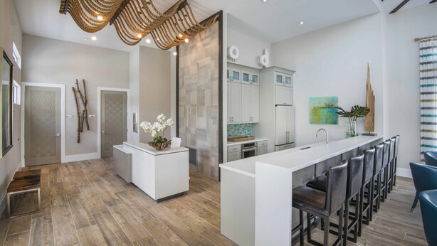 A modern kitchen with a central island, bar stools, and a hanging light fixture. - Veranda Palms 2505 (Kissimmee)