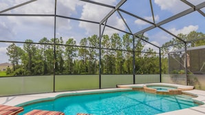 A covered outdoor swimming pool with lounge chairs and a hot tub. - Watersong 457 (Davenport)