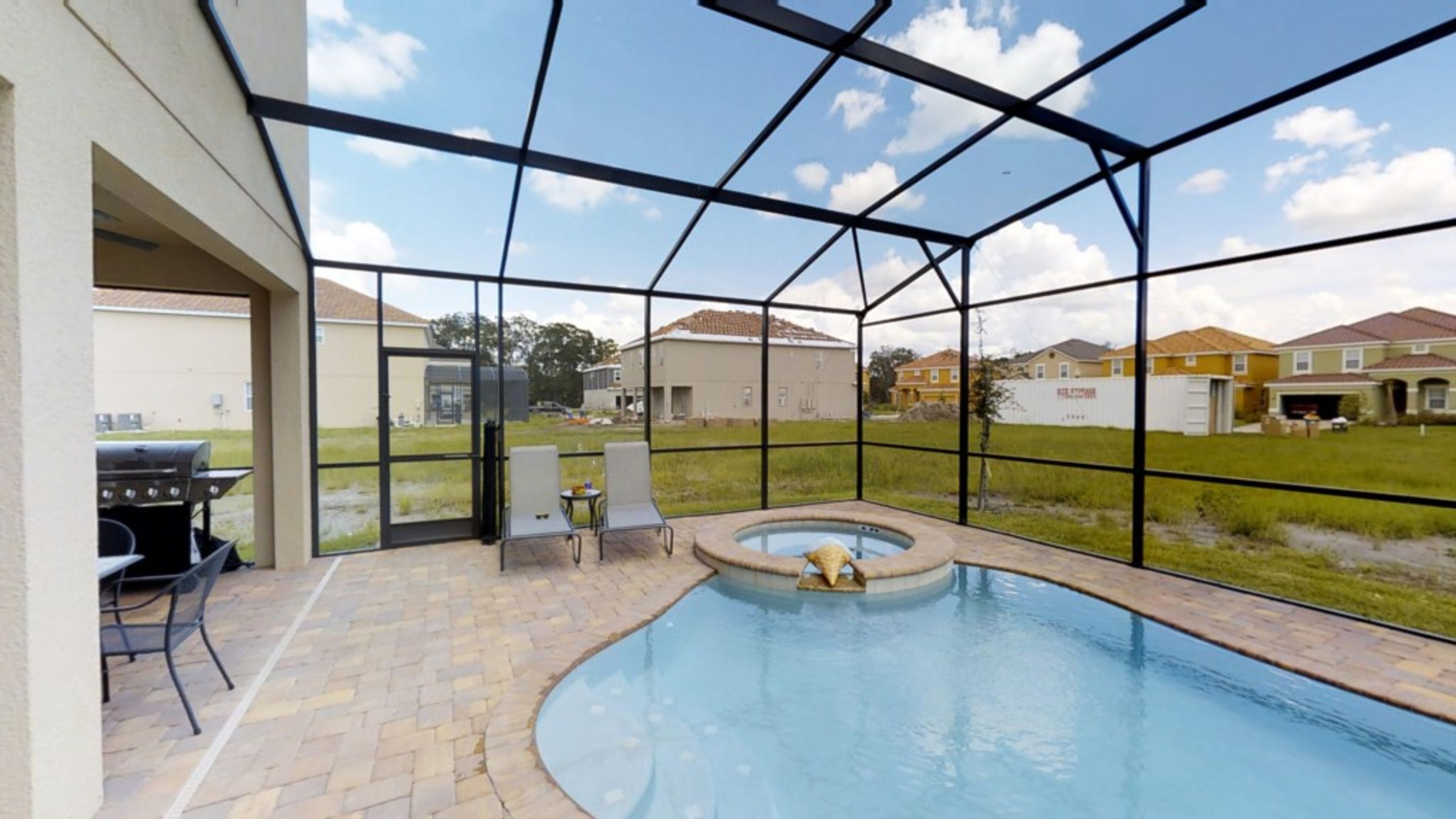 Une piscine extérieure couverte, dotée d’un jacuzzi, de meubles de jardin et d’un espace barbecue.