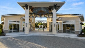 A modern building with a covered entrance, large glass windows, and a paved driveway. - Sonoma Resort 3871 (Kissimmee)