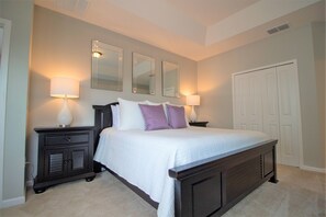 A bedroom with a large bed, two nightstands, a dresser, and a closet. - Sonoma Resort 2663 (Kissimmee)