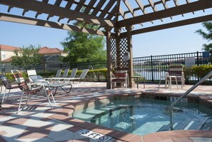 A pool area with lounge chairs and a pergola structure.
