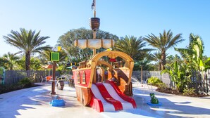 A pirate-themed water play area with a ship structure, slides, and a small boat. - Festival Resort 313 (Davenport)