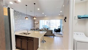 A modern kitchen with granite countertops, dark wooden cabinets, and pendant lighting. - Festival Resort 313 (Davenport)