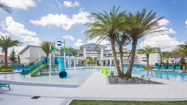 A swimming pool area with a water slide, lounge chairs, and palm trees. - Golden Palms Vacation Resort 4429 (Kissimmee)