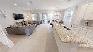 A modern kitchen with a granite countertop and white cabinets. - Golden Palms Vacation Resort 4429 (Kissimmee)