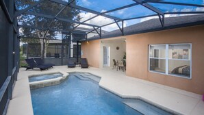 Un espace extérieur abrité avec une piscine, des chaises longues et une table de patio.