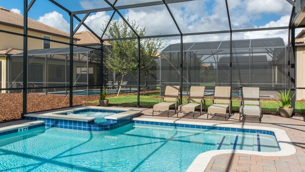 A swimming pool with a hot tub, surrounded by lounge chairs and a covered patio area. - Champions Gate 1470 (Davenport)
