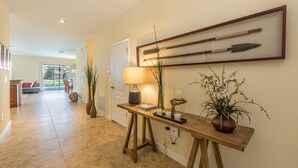 A hallway with a wooden console table, a lamp, and a framed artifact on the wall. - Champions Gate 1470 (Davenport)