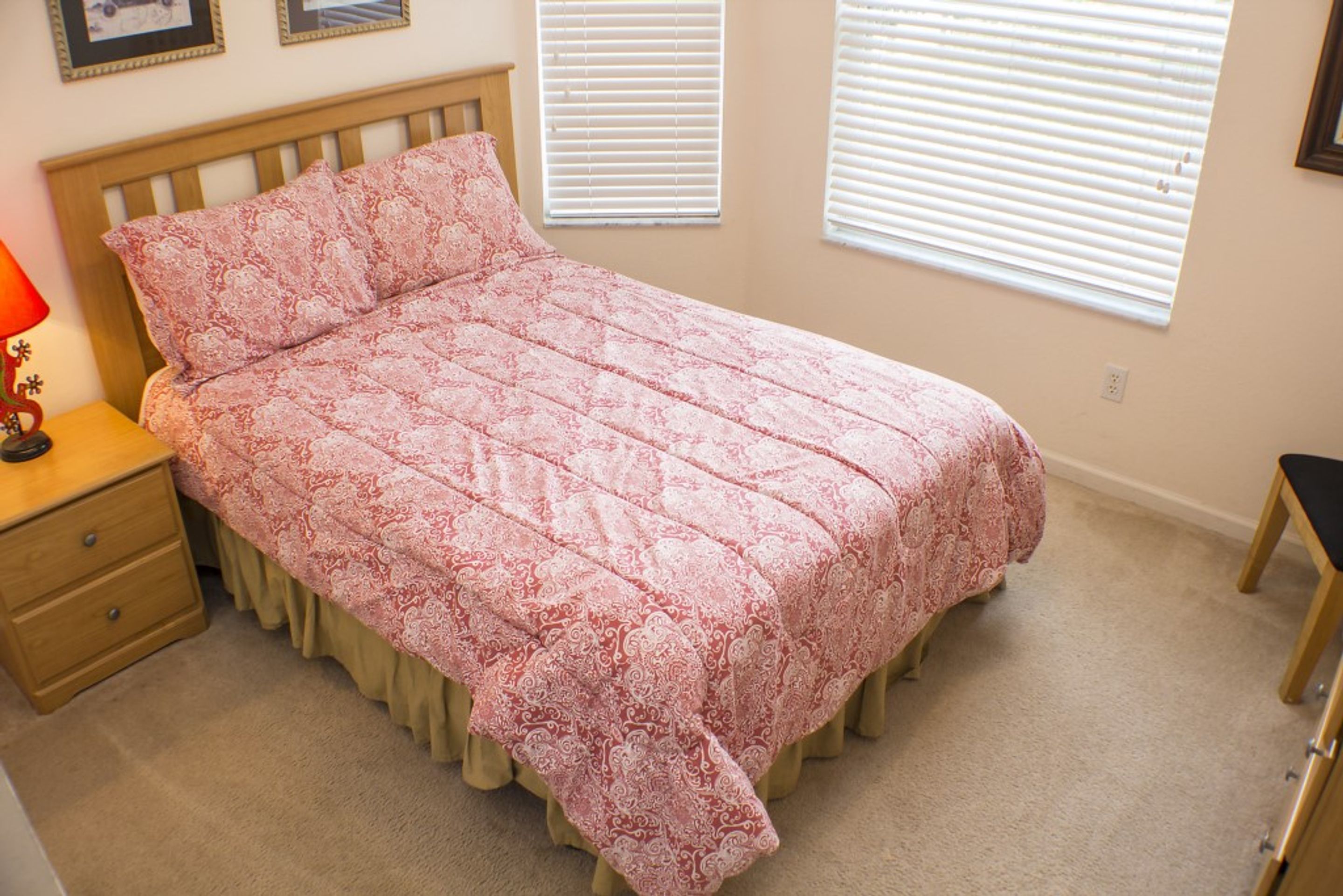A bedroom with a bed, nightstand, and dresser.