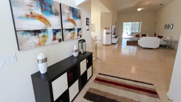 A modern living room with abstract art, a black console table, and a striped rug. - Crystal Cove 929 (Kissimmee)