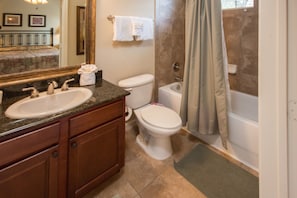 A bathroom with a sink, toilet, bathtub, and a shower curtain. - Bella Piazza 903 - 813 (Davenport)