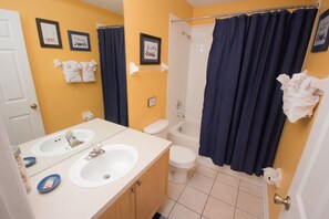 A bathroom with two sinks, a toilet, and a shower. - Windsor Palms 2220 (Kissimmee)
