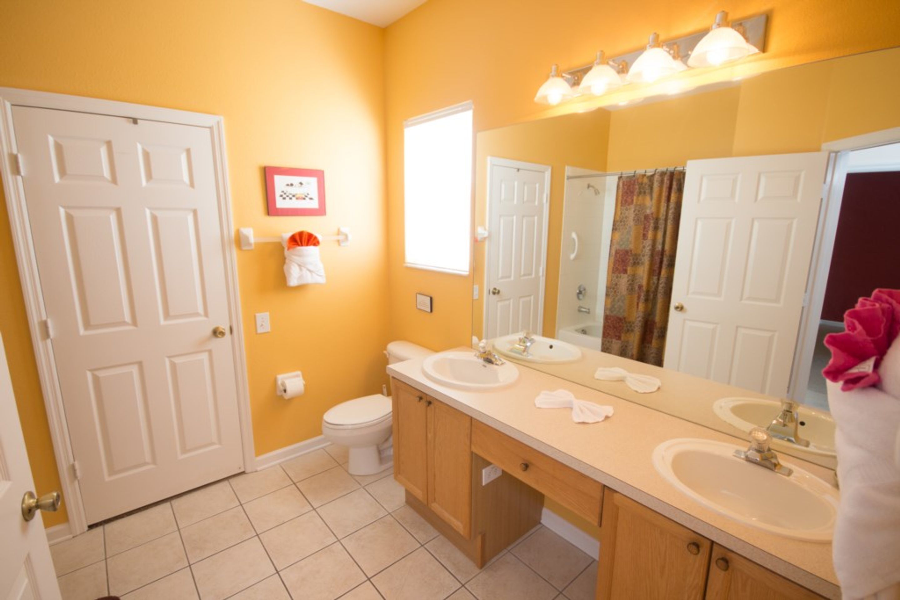 A bathroom with two sinks, a toilet, and a shower.