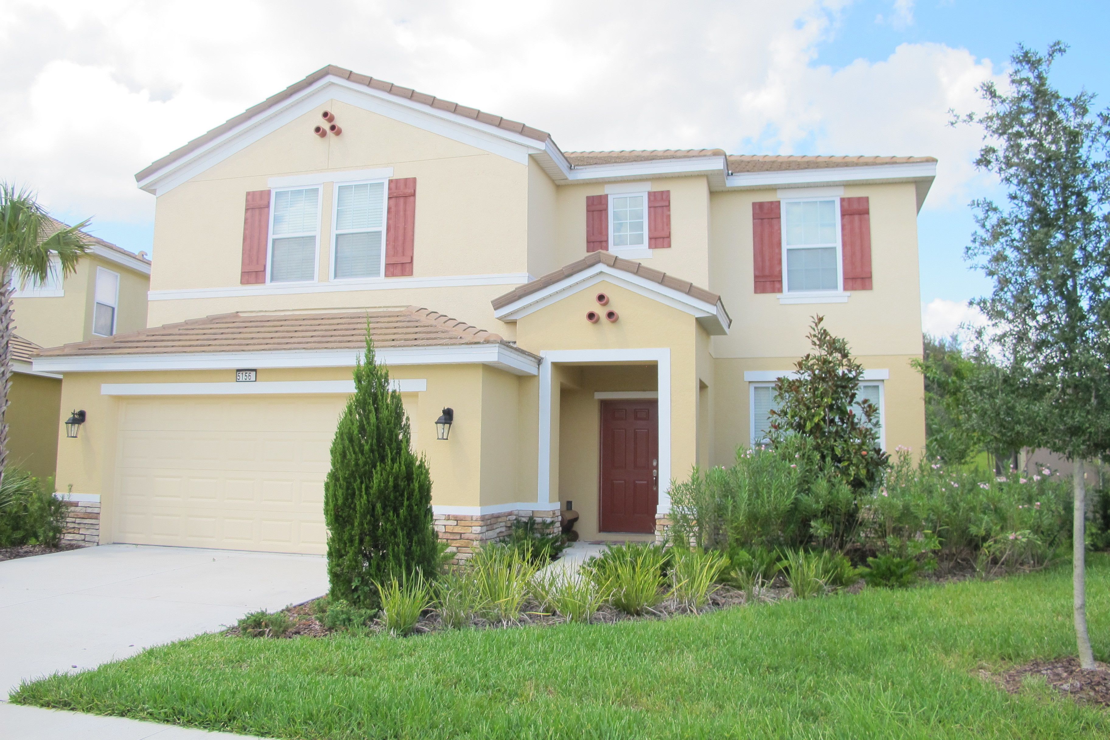 A two-story house with a garage, a front door, and a small porch.