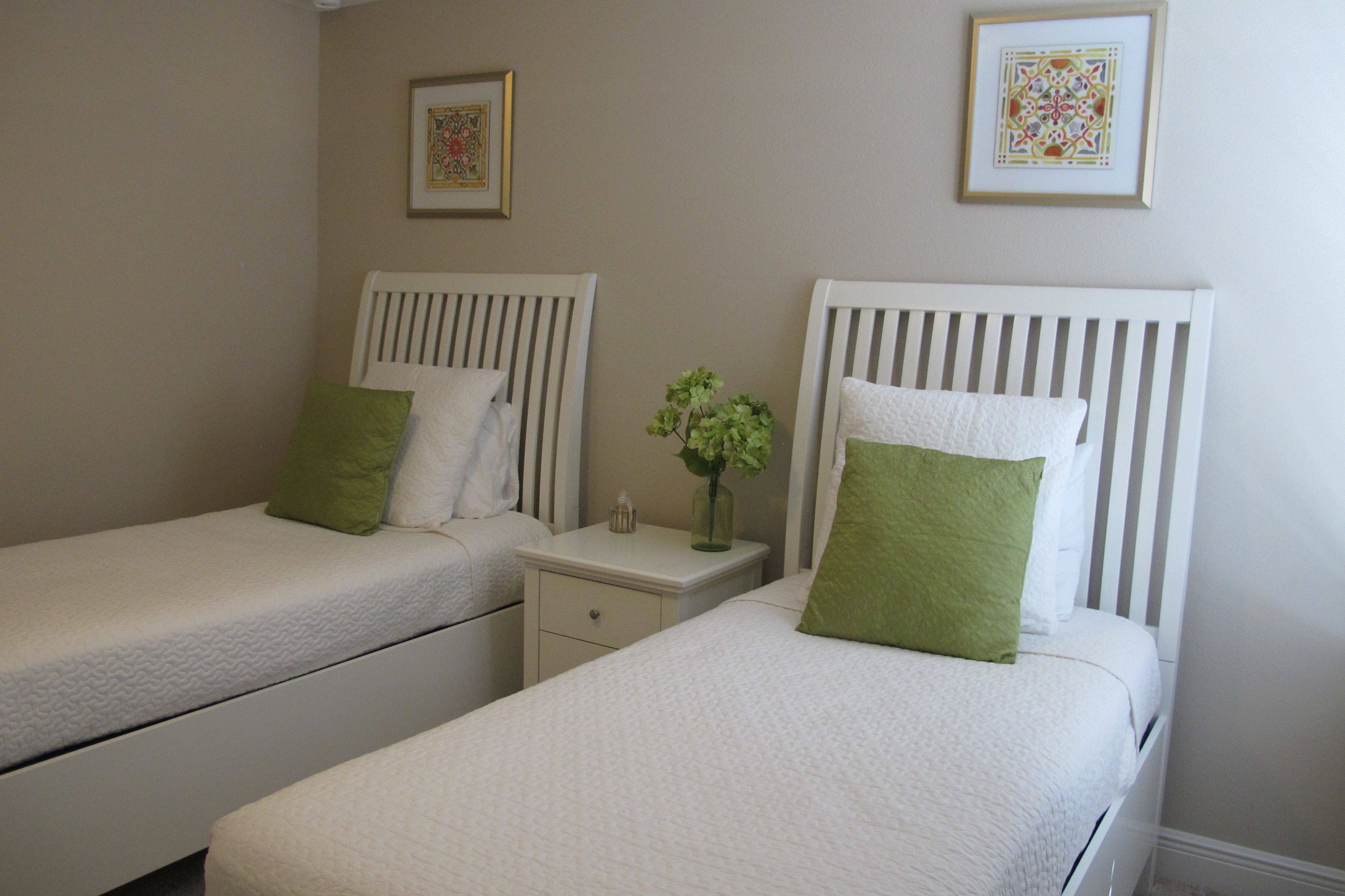 A twin room with two single beds, each with a pillow and a nightstand.