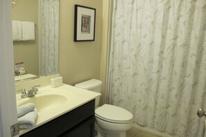 A bathroom with a sink, mirror, toilet, and shower curtain. - Solterra 5156 (Davenport)