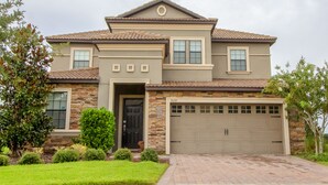 A two-story house with a garage, stone facade, and a well-maintained lawn. - Solterra 5180 B (Davenport)