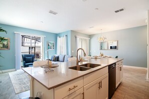 Una cucina moderna con isola centrale, lavastoviglie integrata e un'ampia finestra.