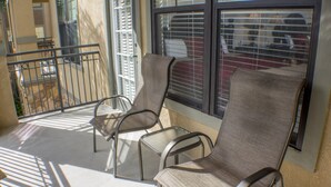 A balcony with three metal chairs and a glass door. - Bella Piazza 904 - 527 (Davenport)