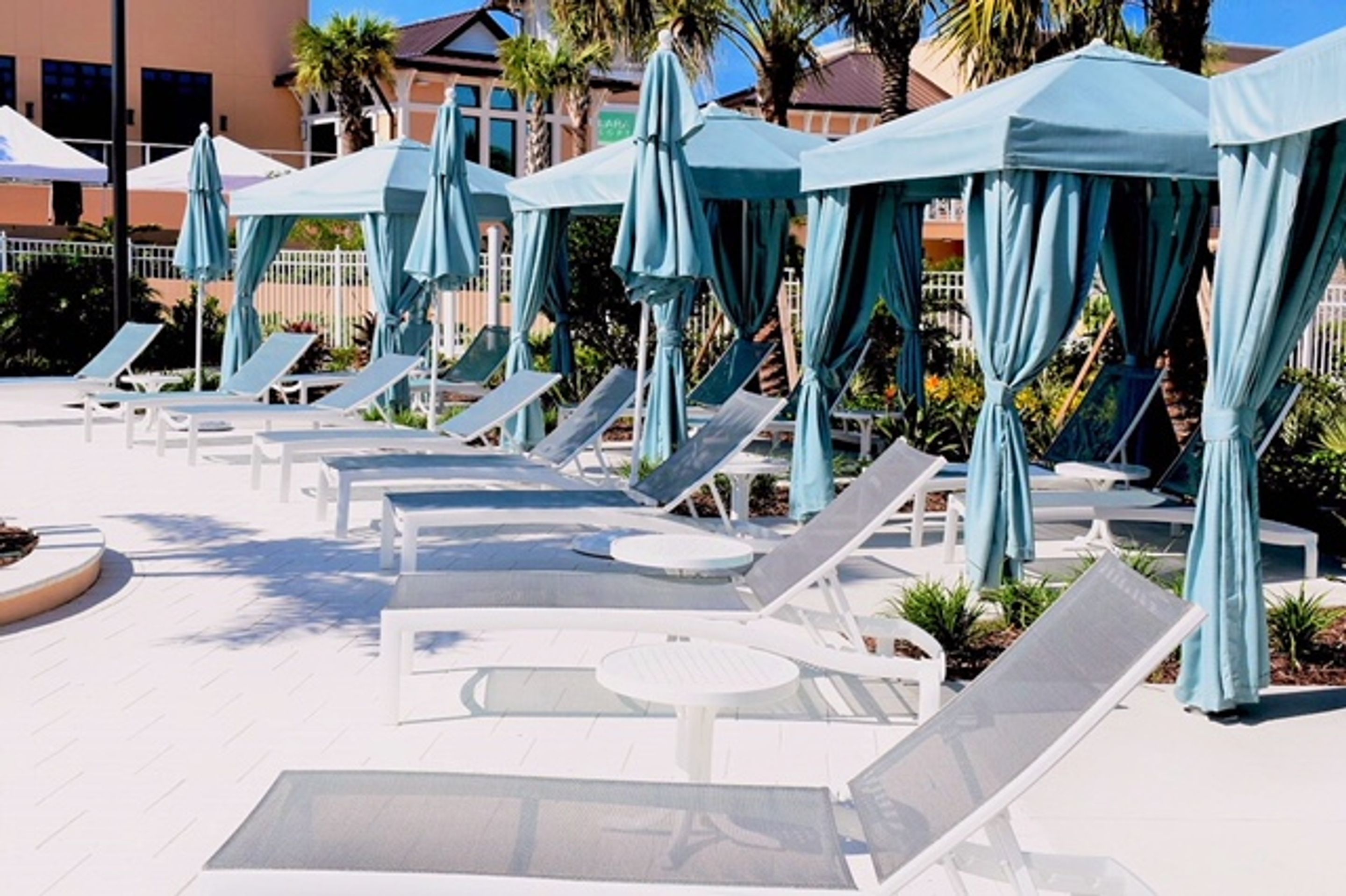 A poolside area with sun loungers and umbrellas.