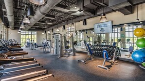 Ett rymligt gym med löpband, styrketräningsmaskiner och fria vikter.