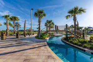 A swimming pool with a tiled deck, palm trees, and a rope bridge. - Storey Lake 4947 (Kissimmee)