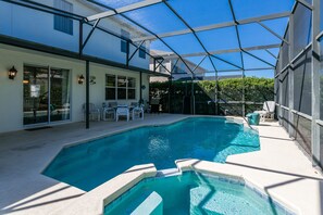 A swimming pool with a glass enclosure, surrounded by outdoor furniture and a house. - Legacy Park 212 (Davenport)
